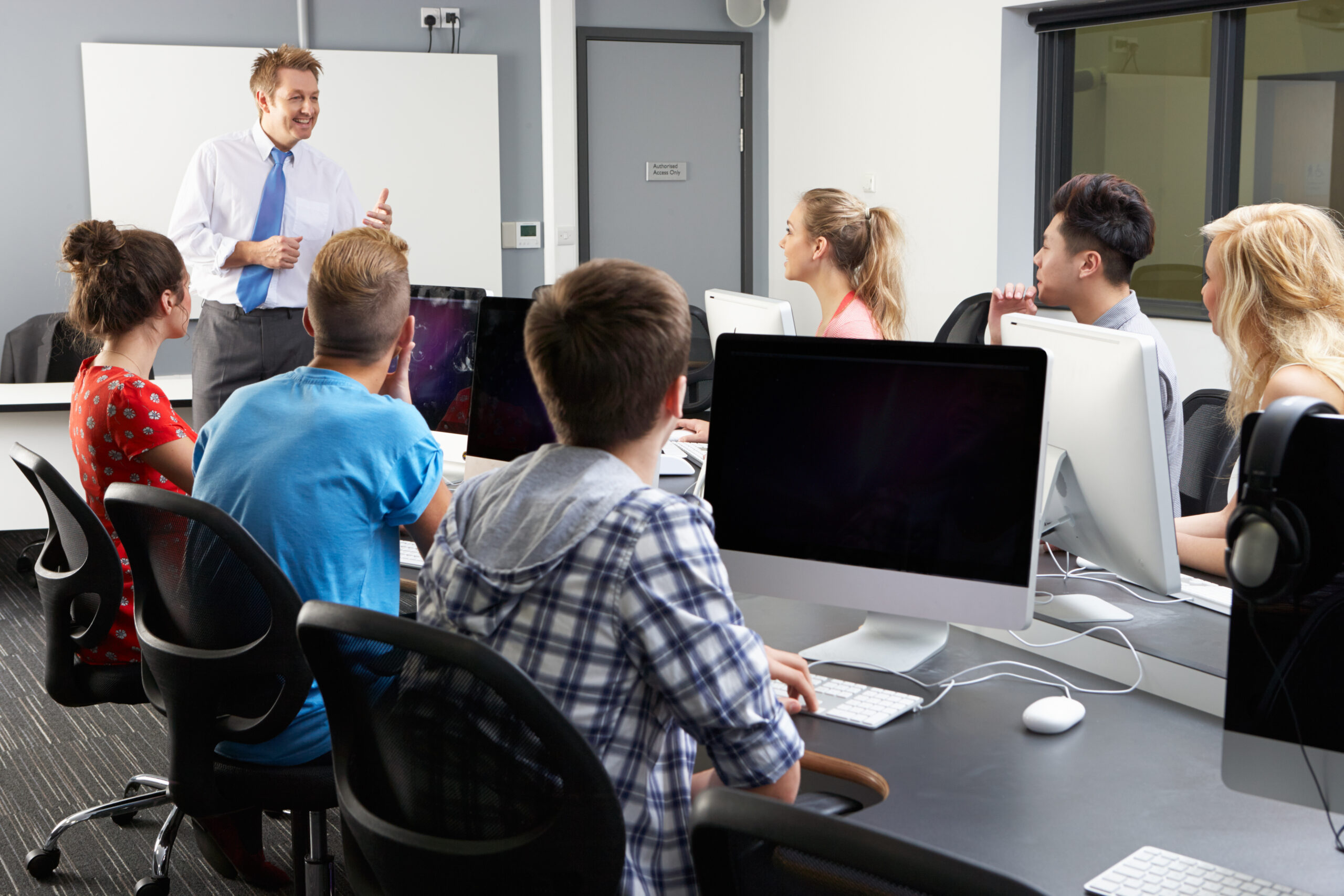 A teacher working with students with intellectual & developmental disabilities to use the Virtual Job Coach online courses.